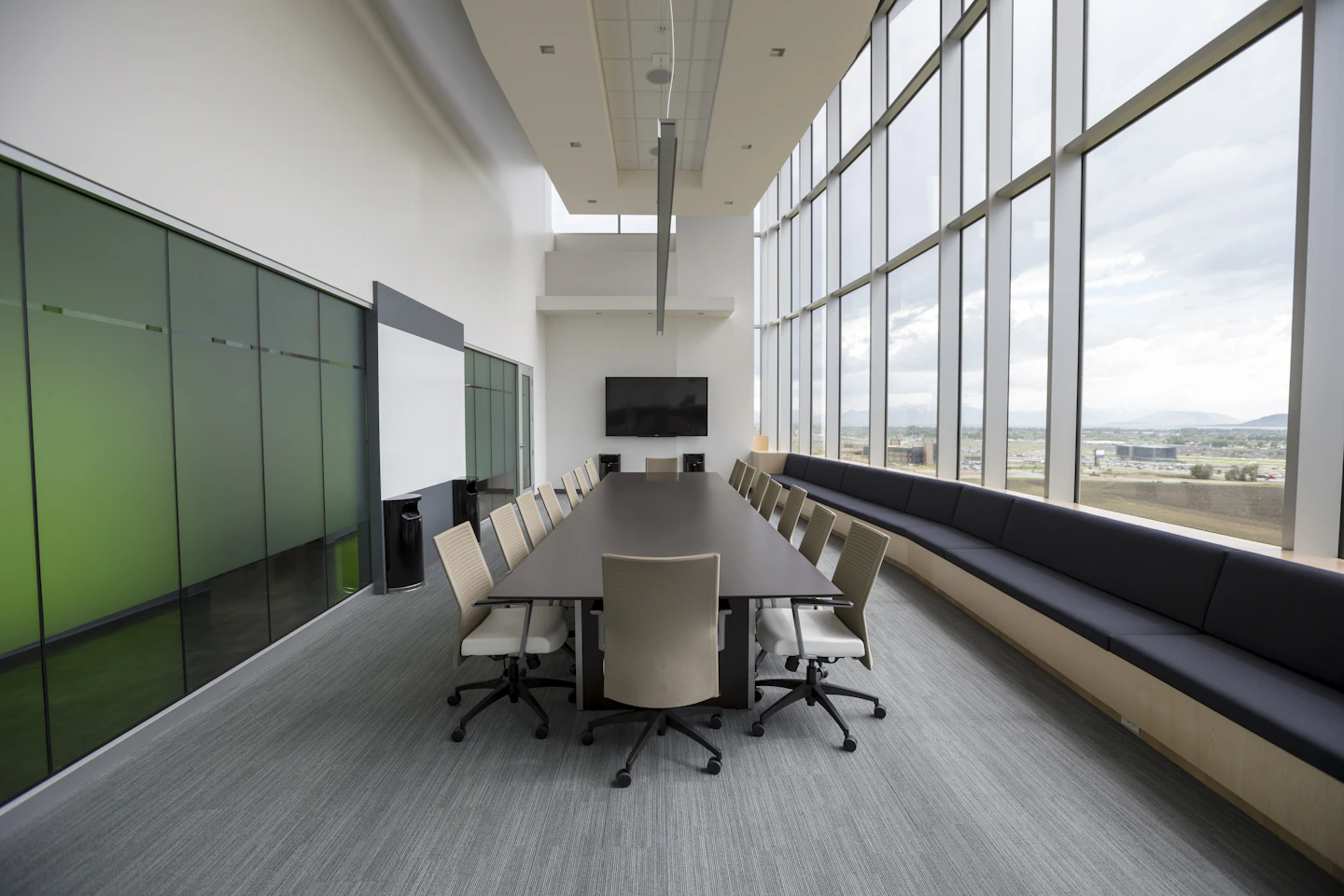 A naturally lit office boardroom with a long meeting table